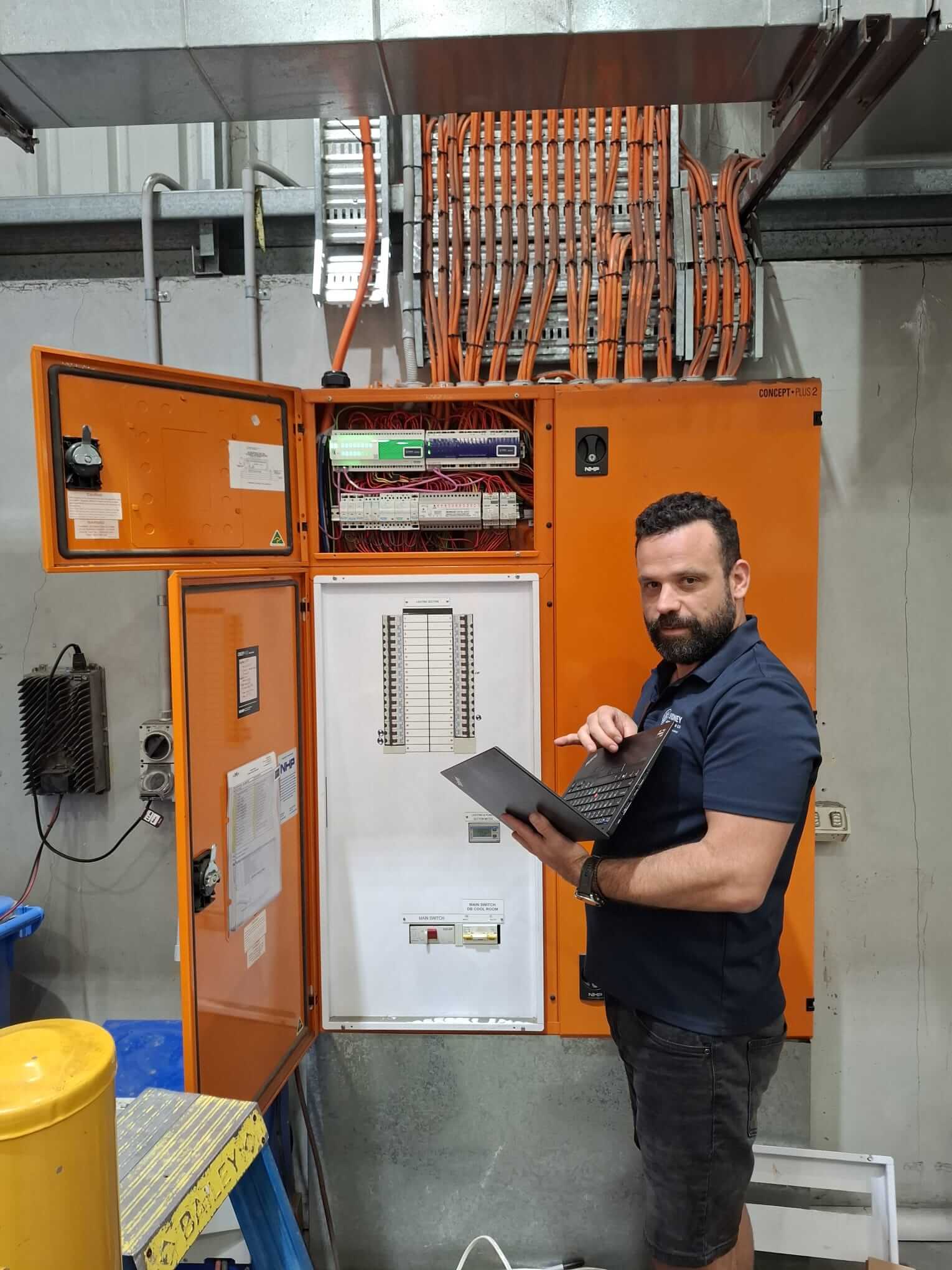 George Skarmoutsos, founder of Sydney Automation Co., diagnosing a commercial C-Bus automation panel on-site in Sydney